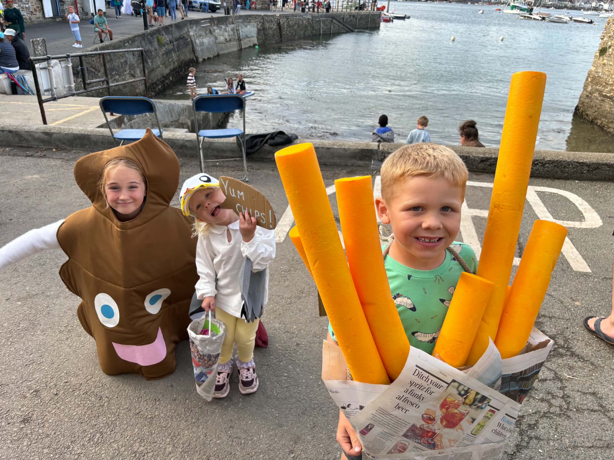 Children in chips, seagull and novelty carnival costumes by Polruan Harbour