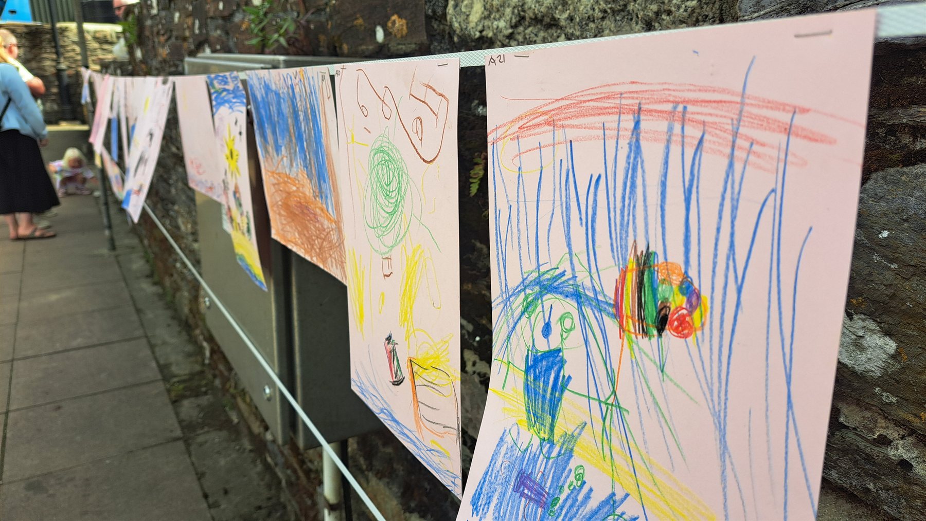 Children's colourful Regatta artwork displayed along a Polruan village lane