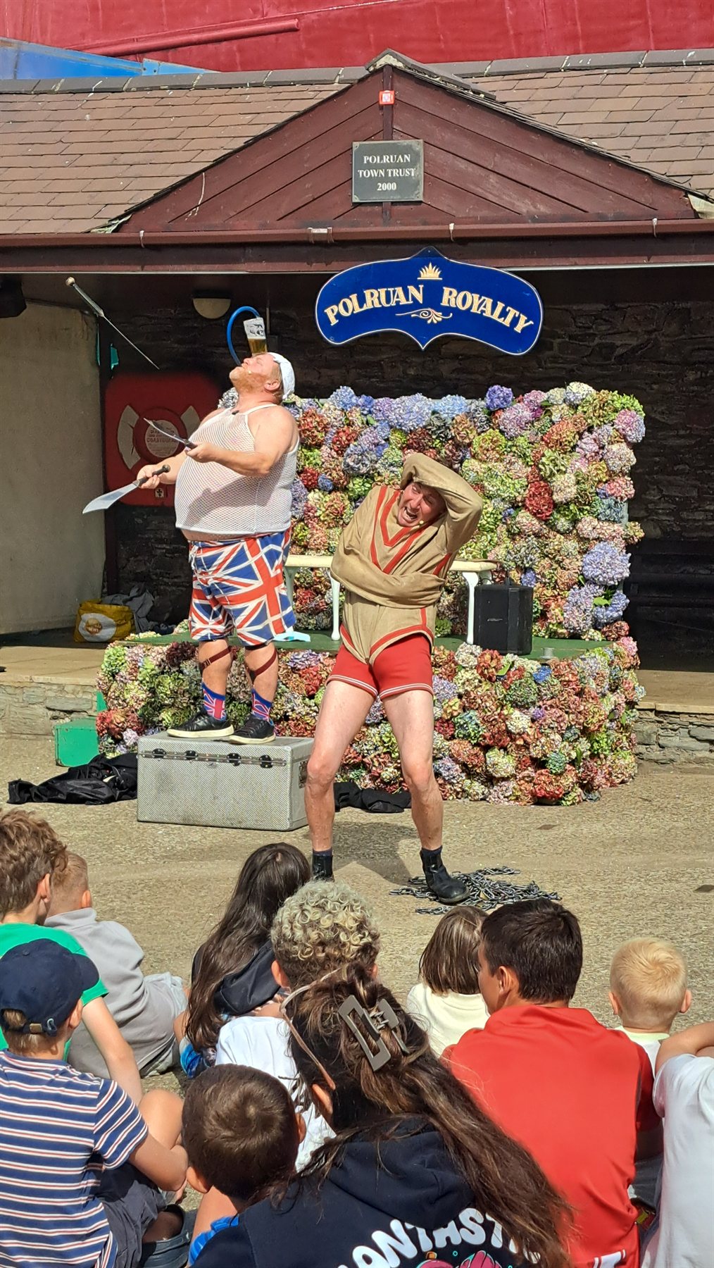 Comedy performers entertaining the crowd on the flower-covered Regatta stage